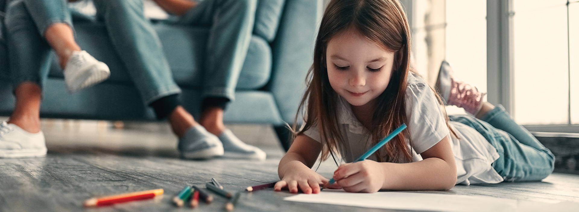 A young child colouring with pencil crayons.